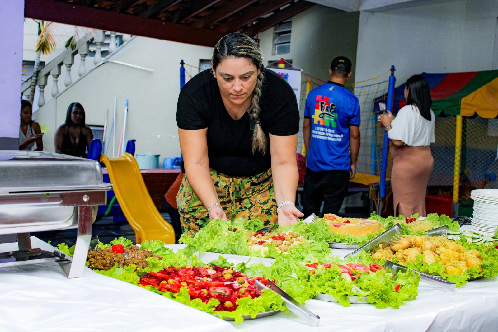 Daniela montando a mesa de saladas do buffet antes de os convidados chegarem